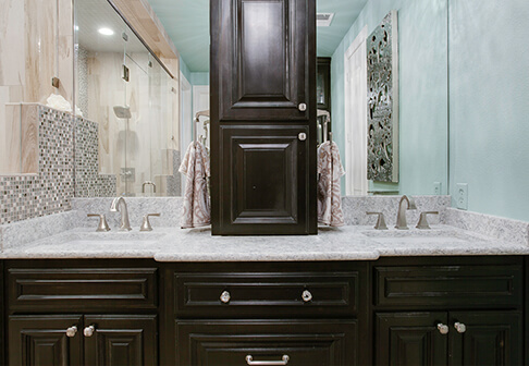Bathroom sink with dark cabinets and white countertop