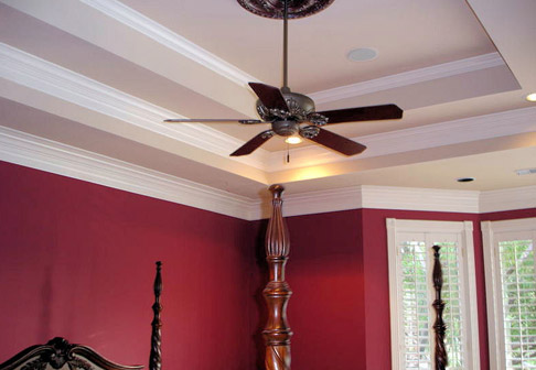 Ceiling fan in room with red walls