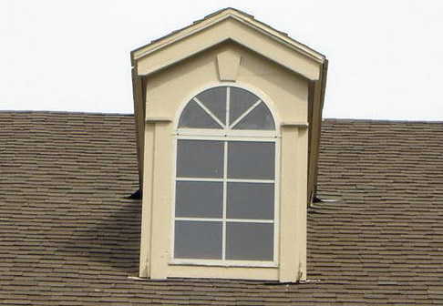 Attic window with fresh pale yellow paint