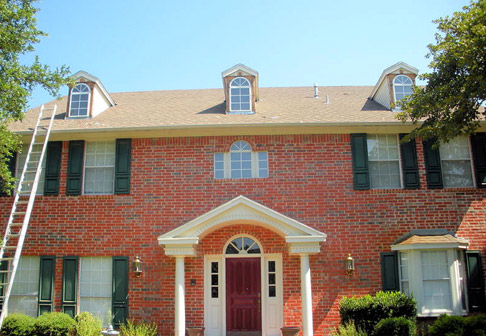 Exterior of red brick house before being painted