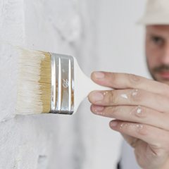 man painting brick white