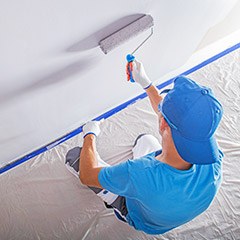 Man painting the walls of a room white