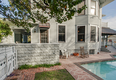 Pool in backyard of house painted white