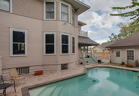 Pool in backyard of house painted pale pink