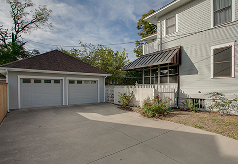Driveway and garage of house painted white