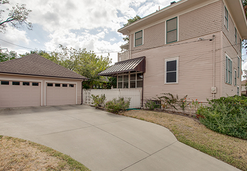 Driveway and garage of house painted pale pink