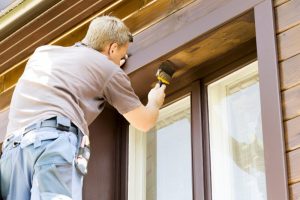 A man painting a home exterior.