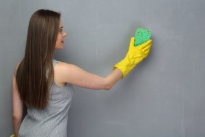 woman washing the walls with a sponge