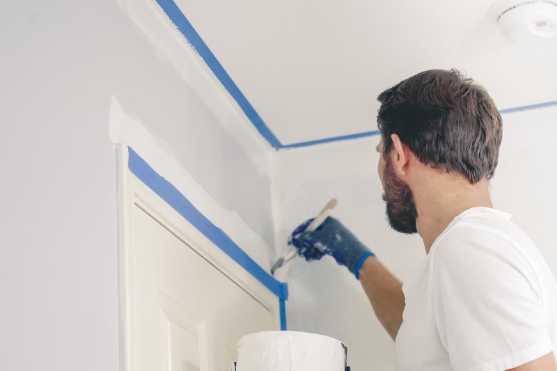 man painting the inside of his home