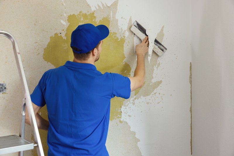 man removing wallpaper