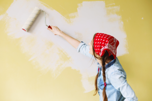 a person painting their home’s wall 