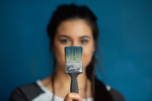 a woman holding a paintbrush 