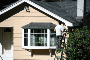 a person painting the exterior of a house