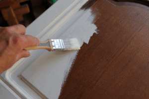 a person painting their kitchen cabinets