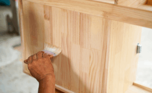 a person touching up their painted cabinets