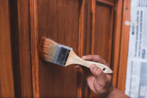 a person painting their cabinets with a brush